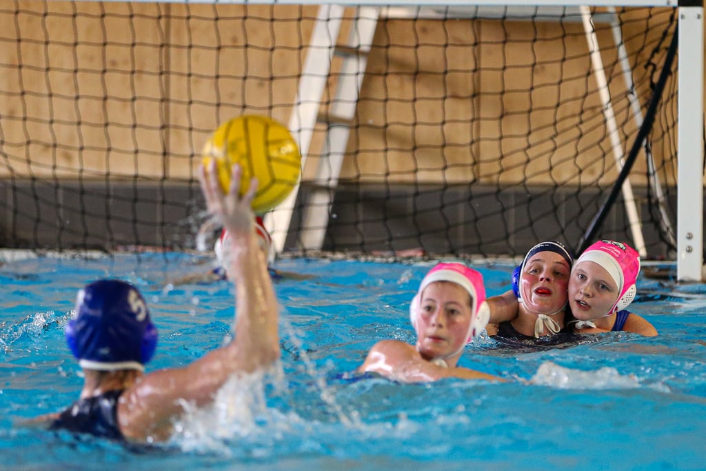 Water polo defenders watching an incoming shot